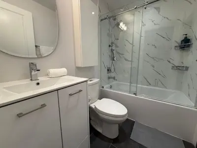 a white bathroom with a toilet and a shower at Gorgeous downtown condo in Toronto