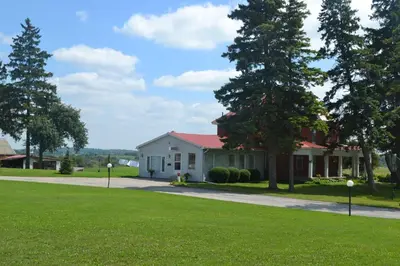 a white house with a red roof at Lighthouse Motel in Walkerton