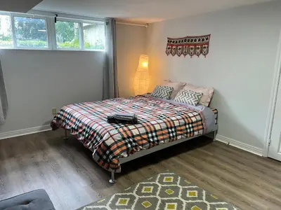 a bedroom with a bed with a blanket and a lamp at Cozy basement 2 bedroom 2 bath with parking in Richmond Hill