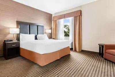 a hotel room with a large bed and a couch at Best Western Plus Fergus Hotel in Fergus