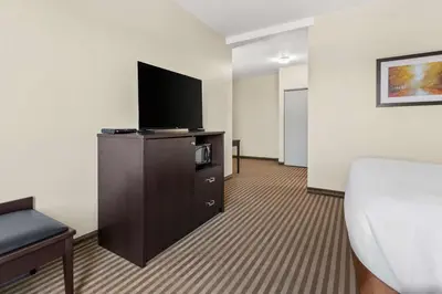 a hotel room with a bed and a flat screen tv at Best Western Plus Fergus Hotel in Fergus