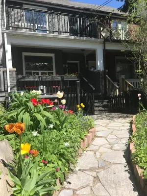 a garden in front of a house with flowers at Beautiful house in central Toronto with backyard in Toronto