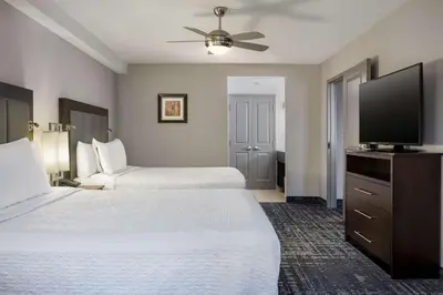 a hotel room with two beds and a flat screen tv at Homewood Suites by Hilton Waterloo/St. Jacobs in Waterloo