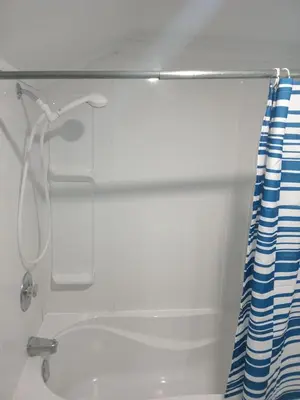 a shower in a bathroom with a shower curtain at Windspire Inn in Port Elgin