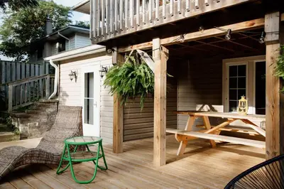 a wooden deck with a table and chairs on a house at The Dainty Petunia in Picton