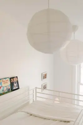 a white bedroom with a bed and a large light fixture at Fox Lane - Prince Edward County Farmhouse in Picton