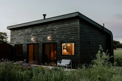 a small house with a bench in front of it at Hygge House Cozy Boutique Guest House in Hillier