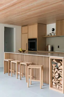 a kitchen with wooden cabinets and tables and a fireplace at nortehaus - Nordic and Japanese inspired escape in Norland