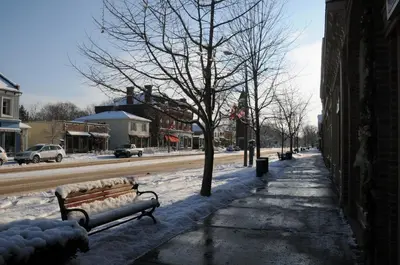 a snow covered street with a bench and trees at Greaves Sweet Escape in Niagara on the Lake