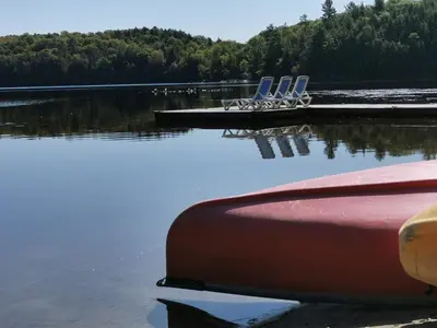 a group of chairs sitting on the shore of a lake at Muskoka Shores Cottages in Port Carling