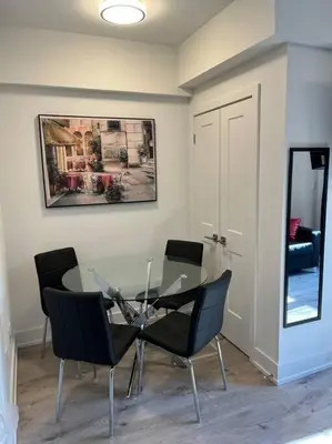 a dining room with a glass table and chairs at Lovely one bedroom condo with free parking in Niagara Falls