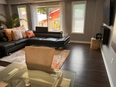 a living room with a leather couch and a glass table at Jahsavvy's Nest in Hamilton