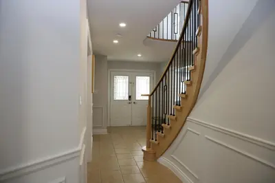 a hallway with a wooden staircase with a door at Lavish 4BR House Near Simcoe Lake & FH Resort in Innisfil