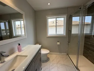 a bathroom with a shower and a sink and a toilet at Lavish 4BR House Near Simcoe Lake & FH Resort in Innisfil