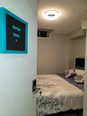 a room with a bed and a blue sign on the wall at RoryHouse in Toronto