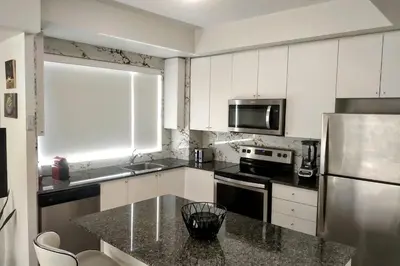 a kitchen with white cabinets and a stainless steel refrigerator at GGP Boutique Townhome in Vaughan