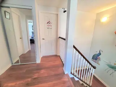 a hallway with a mirror next to a door at Cozy and Quiet Homestay with Private Bathroom in Toronto