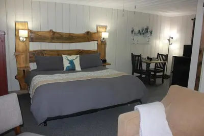 a bedroom with a large bed and a table and chairs at Trillium Resort & Spa in Port Sydney