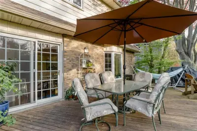 a patio with a table and chairs and an umbrella at Greater Toronto B&B in Oakville