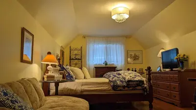 a bedroom with a bed and a tv and a couch at Greater Toronto B&B in Oakville