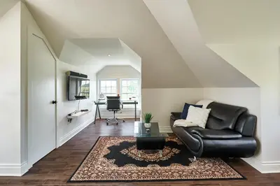 a living room with a black leather chair and a table at Bramasole Bed and Breakfast in Roseneath
