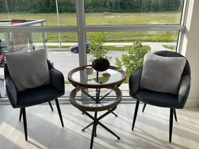 two chairs and a glass table in front of a window at 2 bedroom 2 bath Aquarius, Friday Harbour, Innisfil, Barrie in Innisfil