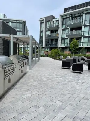a patio with a stove and chairs in front of a building at 2 bedroom 2 bath Aquarius, Friday Harbour, Innisfil, Barrie in Innisfil