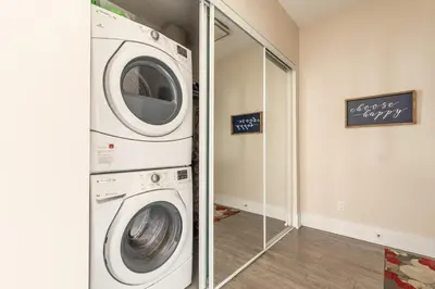 a washer and dryer in a room with a mirror at Luxury King Bed Condo with Stunning City Views in Toronto