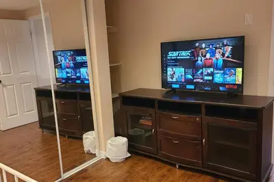 a living room with a flat screen tv on a entertainment center at Spacious and bright unit with natural light. in Pickering