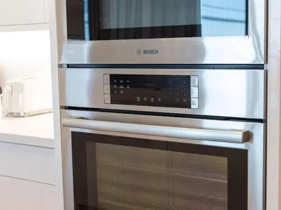a kitchen with an oven with a microwave above it at Pristine Modern 2BR Condo Private BBQ and Balcony in Toronto