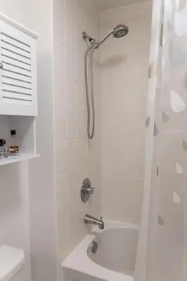 a white bathroom with a shower and a sink at Cityscape 1BR Condo with Private Balcony amd WFH setup in Toronto