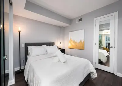 a white bedroom with a large bed with white pillows at One of Toronto s finest 1BR Condo with a WFH Setup in Toronto