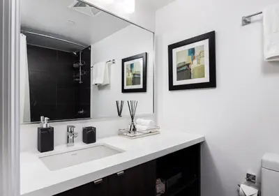 a white bathroom with a sink and a mirror at One of Toronto s finest 1BR Condo with a WFH Setup in Toronto