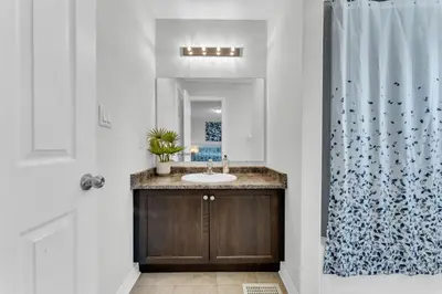 a bathroom with a sink and a shower curtain at Oshawa Family Haven - Luxury 7BR Villa with Cozy Fireplaces & Hot Tub in Oshawa