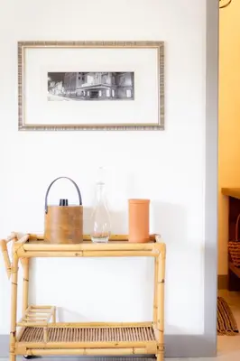 a rattan console table with a picture on the wall at The Barns of Brighton Near Prince Edward County in Brighton