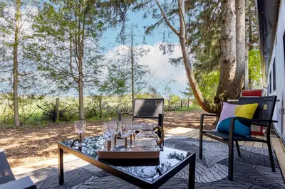 a patio with a glass table and two chairs at The Barns of Brighton Near Prince Edward County in Brighton