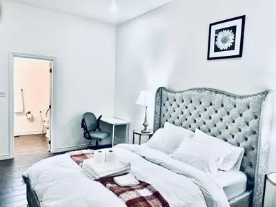 a bedroom with a white bed with a tufted headboard at Lavida Luxury Room #1 in London in London