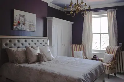 a bedroom with a large bed and a chandelier at Lakehurst Estate in Cobourg