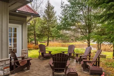 a patio with chairs and a table on a house at Lakeside at Rocky Crest Resort and Golf Club on Joseph Lake in Rosseau