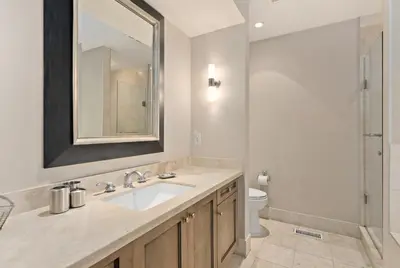 a bathroom with a sink and a toilet and a mirror at Lakeside at Rocky Crest Resort and Golf Club on Joseph Lake in Rosseau