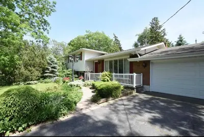 a house with a white garage and a driveway at Cozie cottage at Niagara-On-The-Lake in Queenston