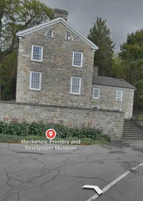 a brick house with a sign in front of it at Cozie cottage at Niagara-On-The-Lake in Queenston