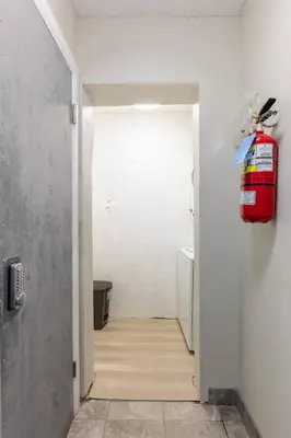 a hallway with a fire extinguisher on the wall at ENTIRE BACHELOR UNIT EN-SUITE UPTOWN WATERLOO - e4 in Waterloo
