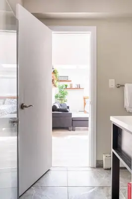 an open door to a living room with a couch at ENTIRE BACHELOR UNIT EN-SUITE UPTOWN WATERLOO - e4 in Waterloo