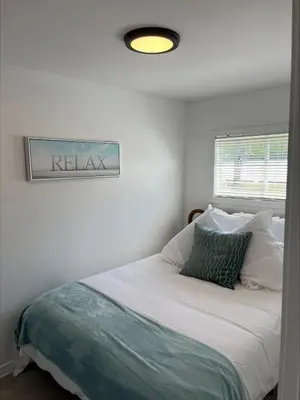a bedroom with a bed with a sign on the wall at Casa Di Nonna in Wasaga Beach
