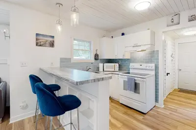 a kitchen with a counter and a blue chair at Mary Jane's Cottage in Crystal Beach