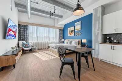 a bedroom with a king sized bed and a table at Cannery Lofts Niagara in Niagara Falls