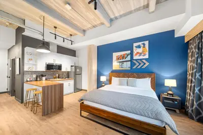 a bedroom with a bed and a blue wall at Cannery Lofts Niagara in Niagara Falls