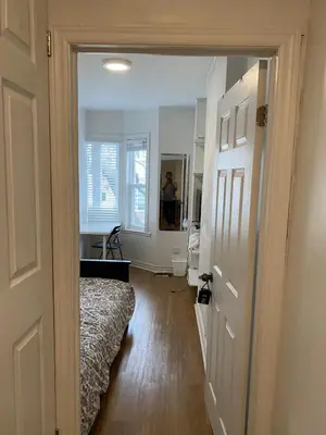 a hallway with a bed and a person in a mirror at Single Room with SHARED Bathroom 536C in Toronto