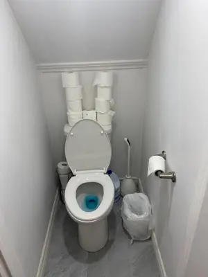 a small bathroom with a toilet with a bunch of towels at Single Room with SHARED Bathroom 536C in Toronto